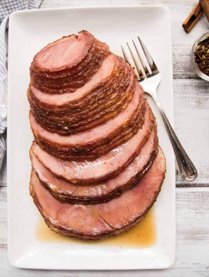 boneless brown sugar ham platted on a rectangular platter