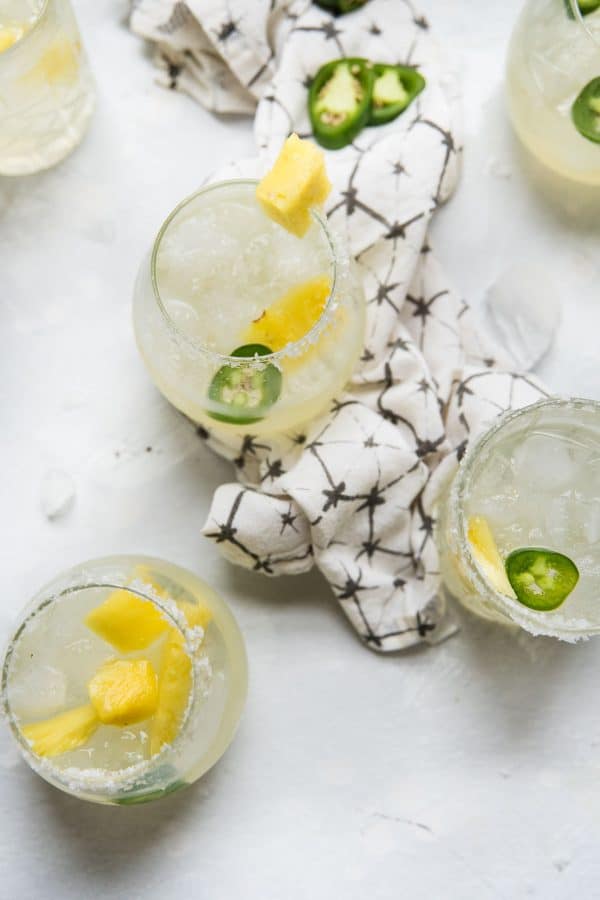 overhead of glasses filled with spicy pineapple margaritas