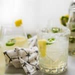 Spicy Pineapple Margarita with salted rim and ingredients in the background