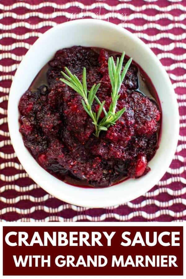 overhead angle of chopped cranberry sauce in a white bowl with sprig of rosemary