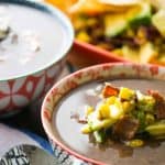bowls of black bean soup with bacon corn salsa