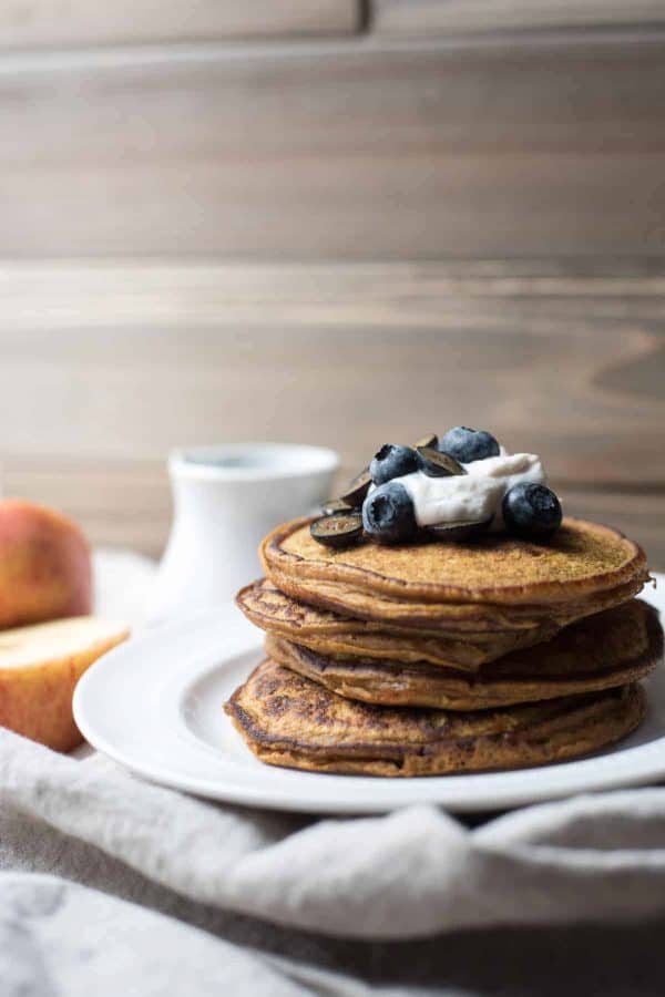stack of pumpkin spice blender pancakes topped with yogurt and blueberries
