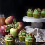 assortment of cupcakes with green apple frosting and black background