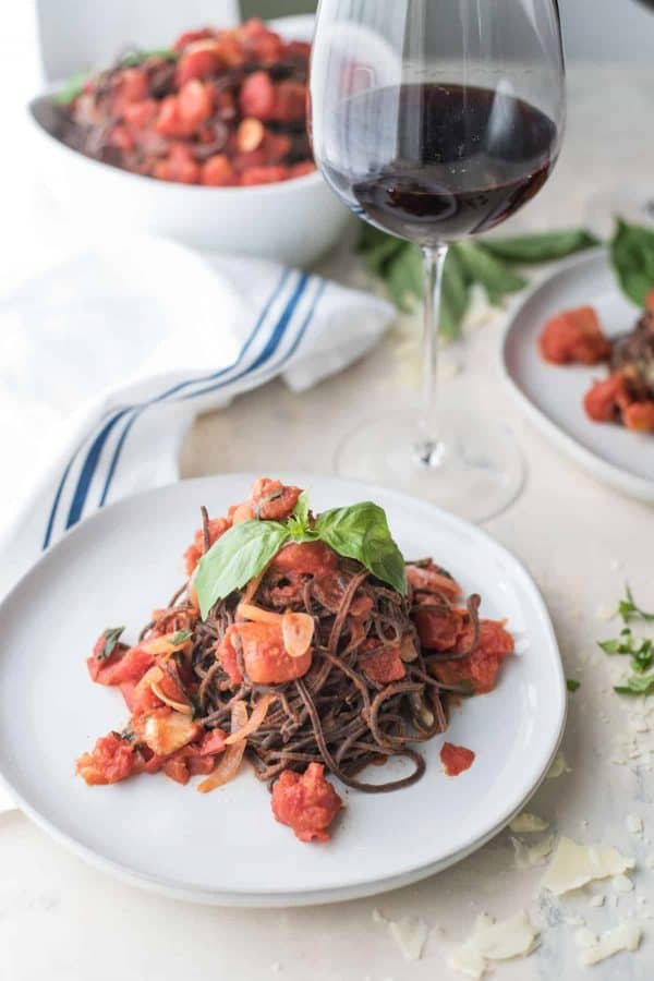 black bean spaghetting with chunky tomato sauce on a plate