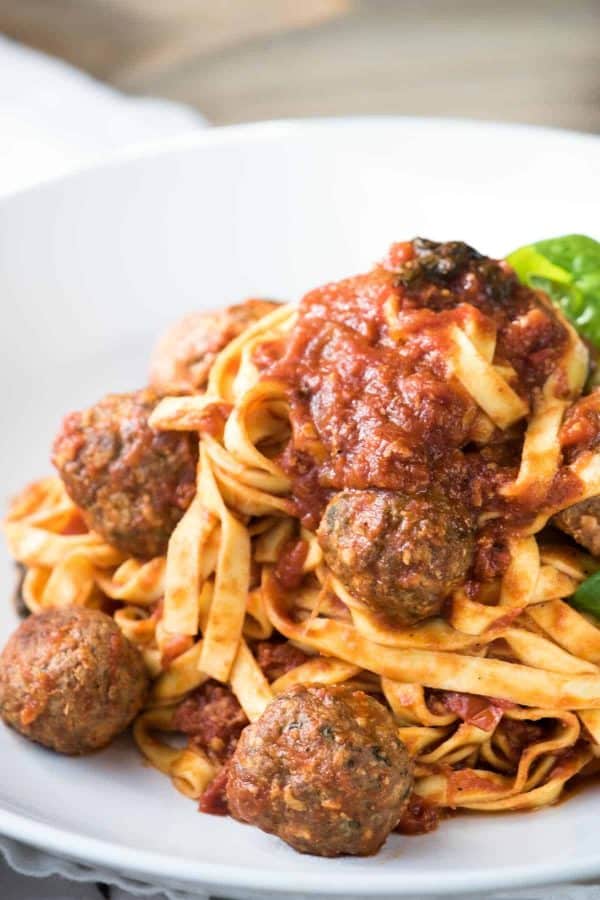 meatballs on top of fresh linguine with extra sauce