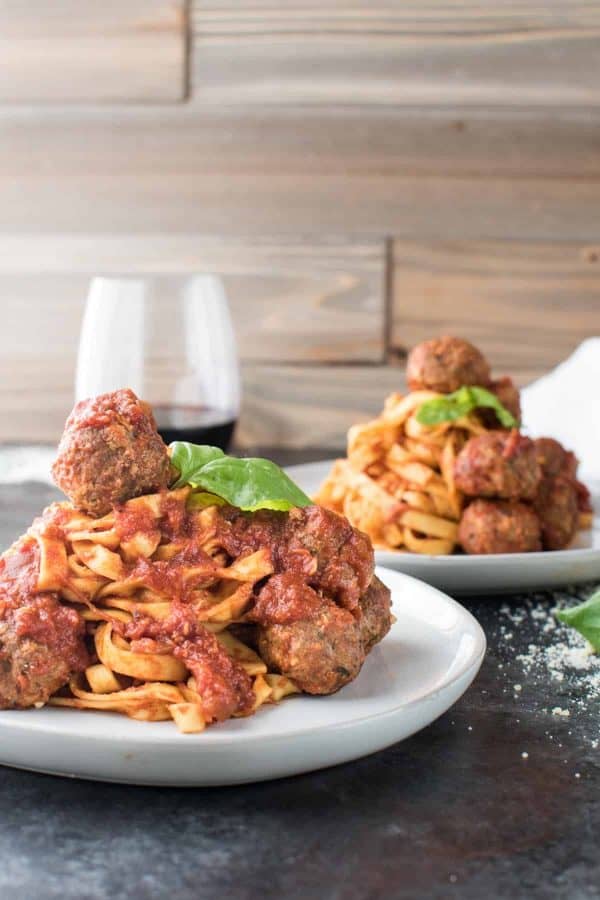 piles of fresh pasta with sauce covered meatballs