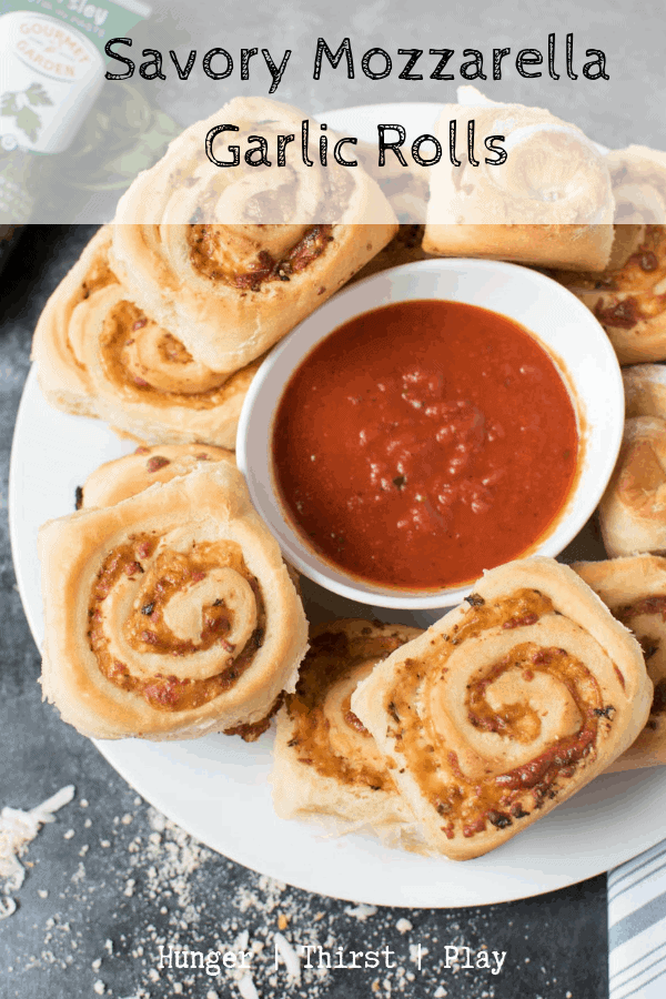 Tender soft bread rolled around cheesy mozzarella, tangy parmesan cheese, garlic, butter, and parsley for the ultimate savory roll. #garlicrolls #cheesybread