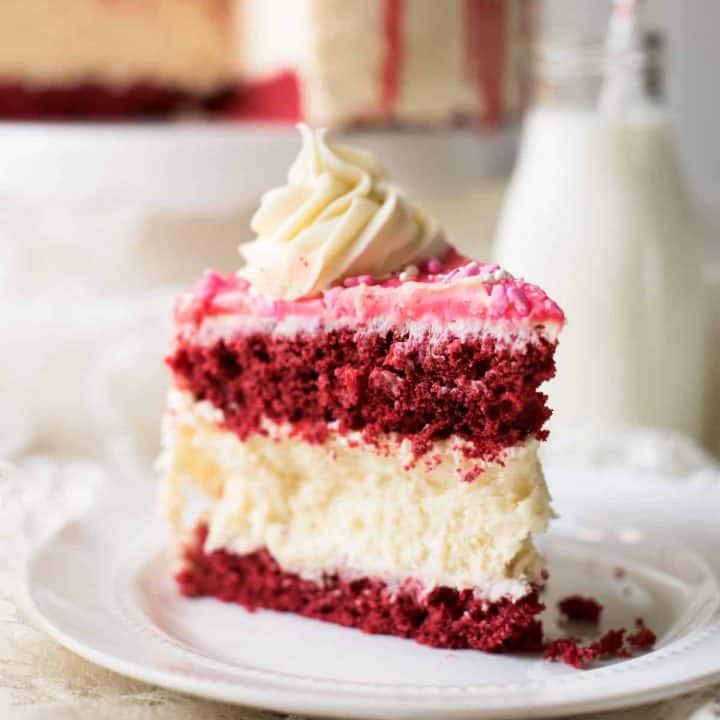 Creamy New York style cheesecake between layers of red velvet cake.