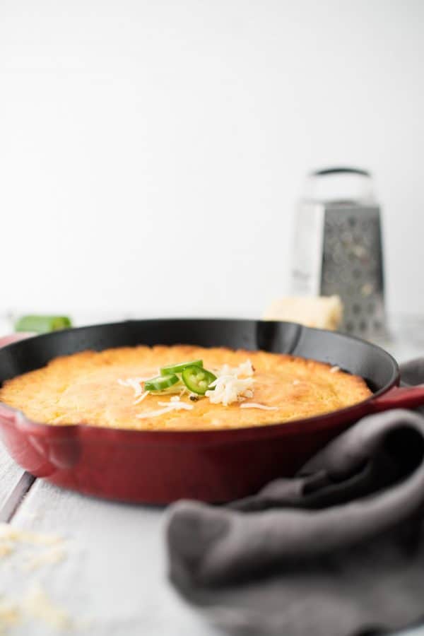 side view of cornbread in a red cast iron skillet