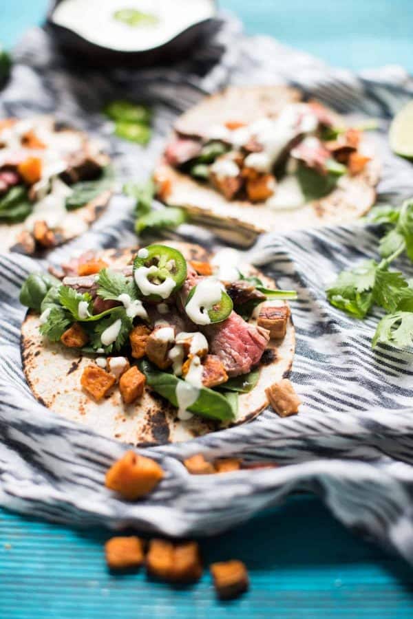 corn tortillas topped with flank steak, sweet potato and jalapeno crema