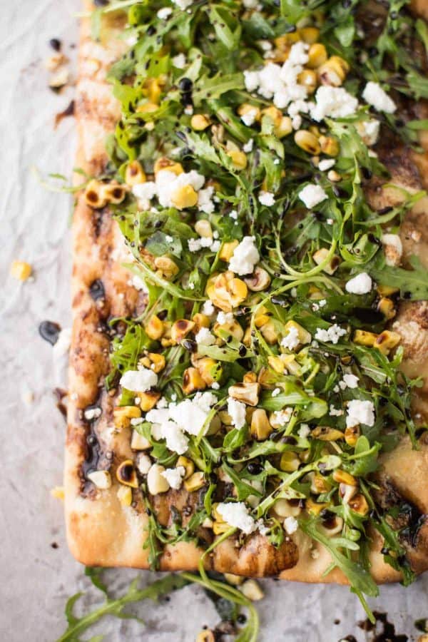 Simple Summer Flatbread with Grilled Corn, Arugula, Mascarpone + Goat Cheese. Just the right amount of crunch, creamy, sweet and savory - made in a flash!