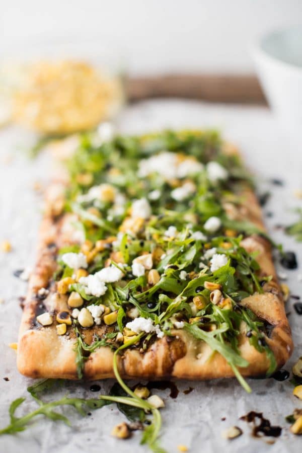 Simple Summer Flatbread with Grilled Corn, Arugula, Mascarpone + Goat Cheese. Just the right amount of crunch, creamy, sweet and savory - made in a flash!