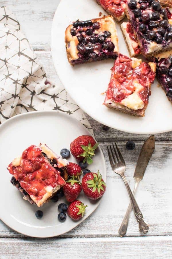 Red White and Blue Cheesecake Bars are a delicious Patriotic sweet treat with fresh summer fruit, creamy filling and crunchy gluten free crust.