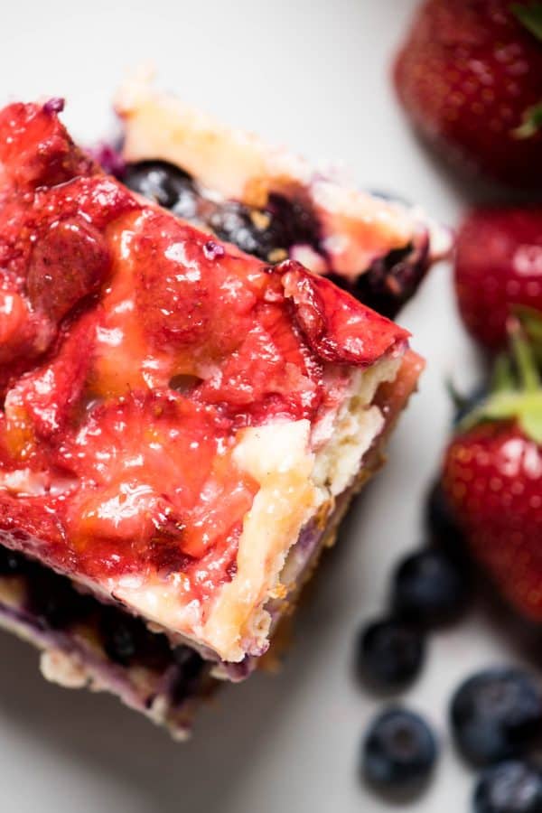 Red White and Blue Cheesecake Bars are a delicious Patriotic sweet treat with fresh summer fruit, creamy filling and crispy gluten free crust.