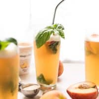 Summer Peach Basil Gin Floats are the perfect cocktail to beat the heat this summer. Frozen peach sorbet sweetens and chills herbaceous gin, fresh basil, and fizzy club soda. Not too sweet, incredibly refreshing. #cocktails #summer #gindrinks #poolparty #peach #basil #gin