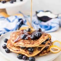 Maple syrup pouring onto blueberry pancakes