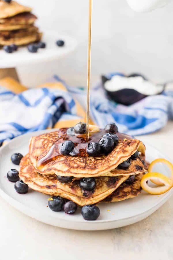 Maple syrup pouring onto blueberry pancakes