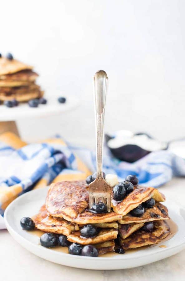 Stack of blueberry lemon pancakes with fork sticking out.