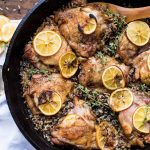 Crispy chicken thighs with lemon and wild rice in cast iron skillet