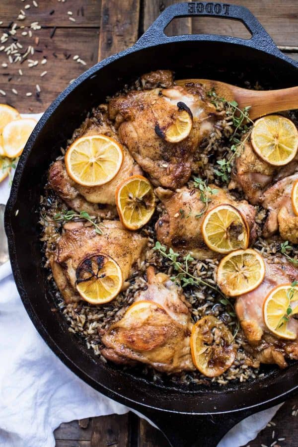 Crispy chicken thighs with lemon and wild rice in cast iron skillet