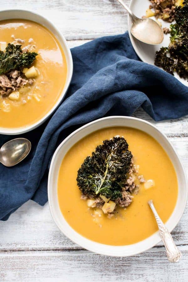 Overhead view of sausage apple butternut squash soup with crispy kale
