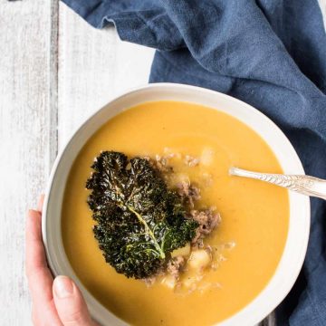 Overhead view of classic butternut squash soup with crispy kale