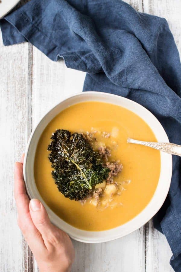 Overhead view of classic butternut squash soup with crispy kale