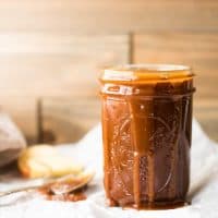 Jar of salted caramel sauce with gooey caramel drips down the side.