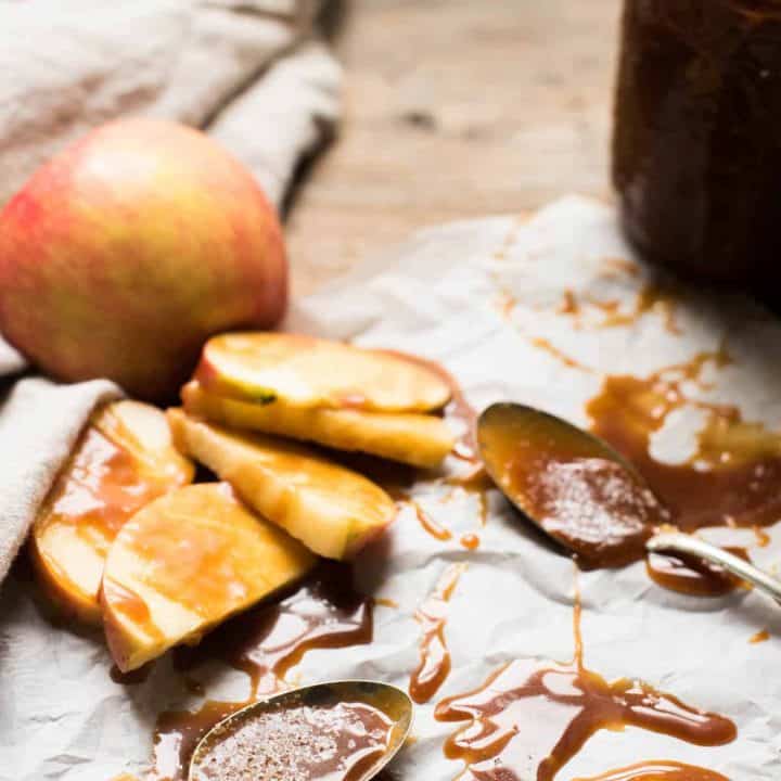 Spoons and apple slices covered in gooey salted caramel sauce