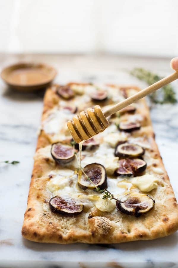 Honey drizzled over fig and goat cheese flatbread