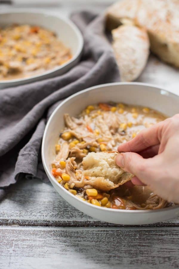 crusty bread dipped into hearty instant pot chicken and wild rice soup