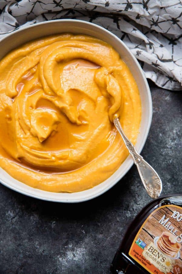 bowl of creamy butternut squash with drizzle of maple syrup