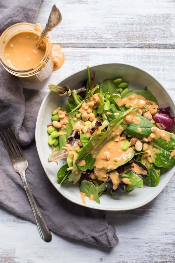 overhead photo of thai peanut dressing and a salad dressed