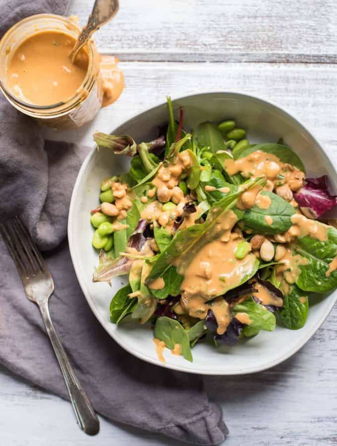 overhead photo of thai peanut dressing and a salad dressed