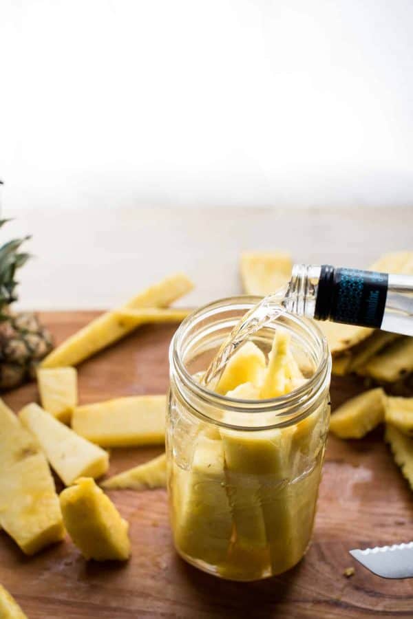 tequila pouring over fresh cut pineapple