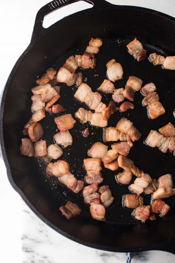 pork belly lardons crisped up in a cast iron pan