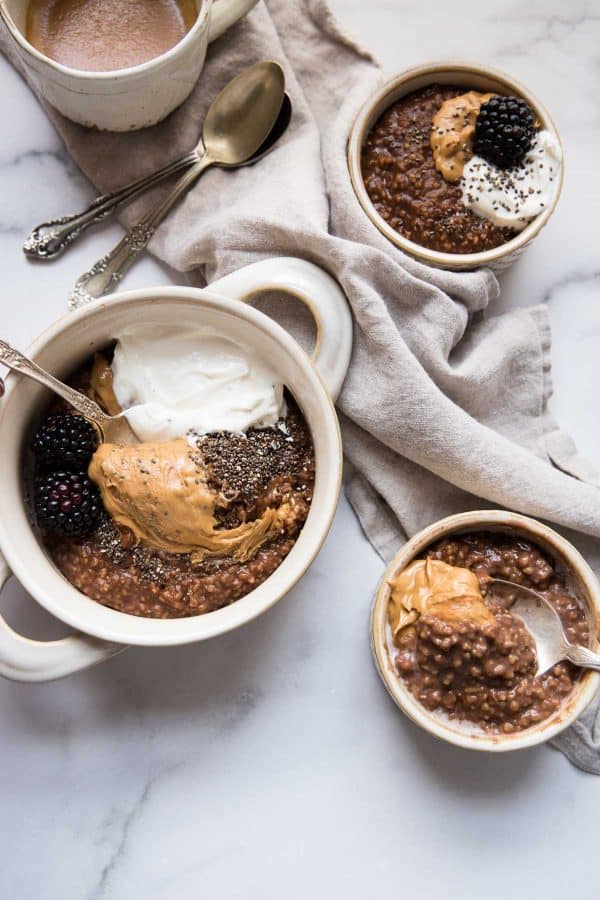 three bowls of chocolate oatmeal with different toppings