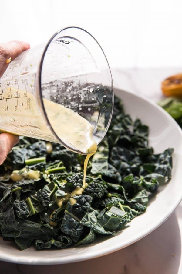 dressing pouring over kale salad