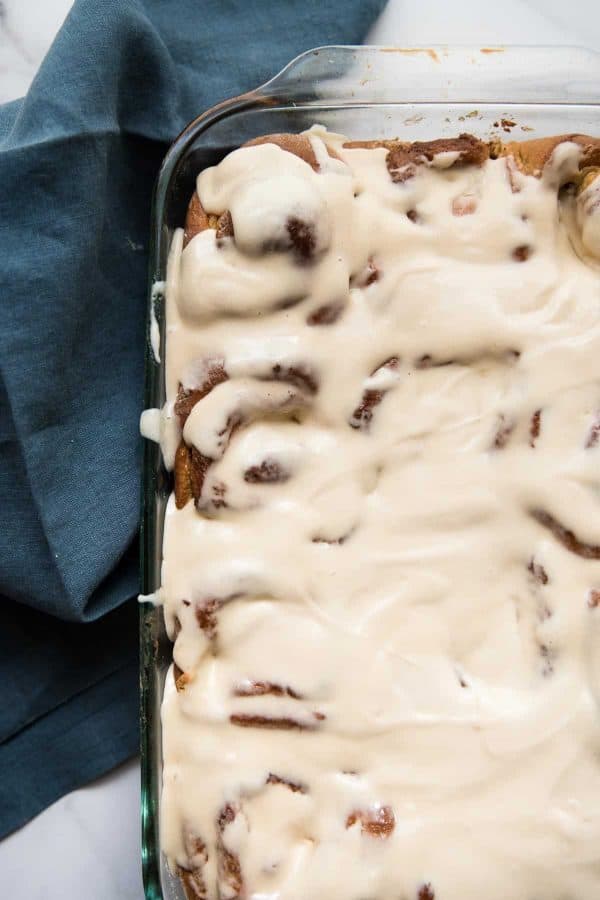 tiramisu cinnamon rolls freshly frosting in the baking dish