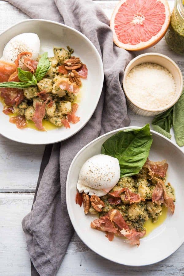 overhead view of plated cauliflower gnocchi in pesto with prosciutto