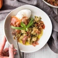 adjusting a bowl of cauliflower gnocchi with pesto