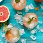 glasses of grapefruit sangria on a bright blue back drop