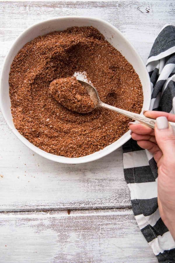 spooning spice rub from a bowl