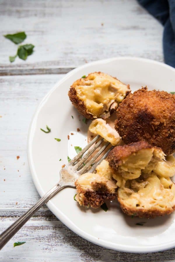 tuna mac and cheese balls cut open with a fork