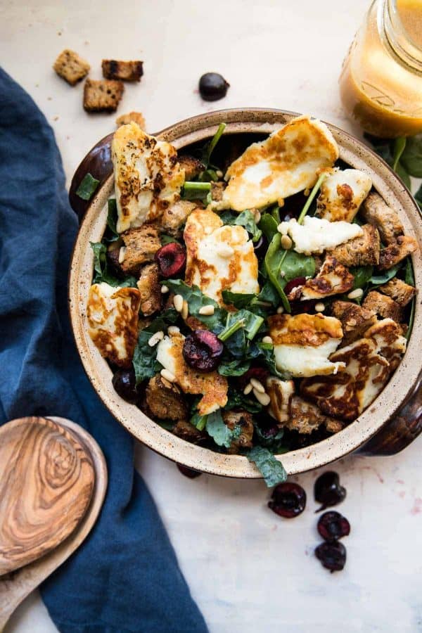 fried halloumi cheese and fresh cherries in a salad bowl