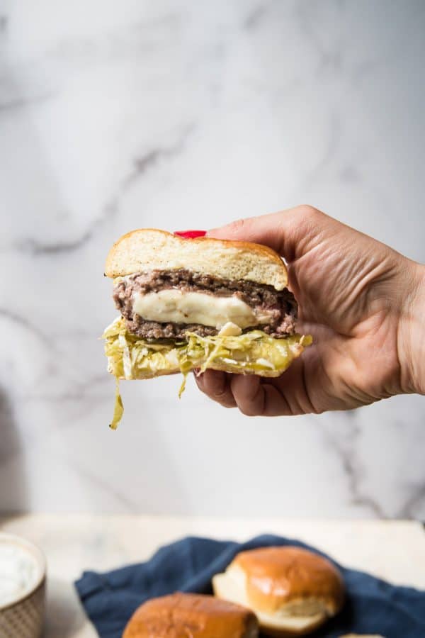 feta stuffed lamb burger sliced in half with cheese melting out