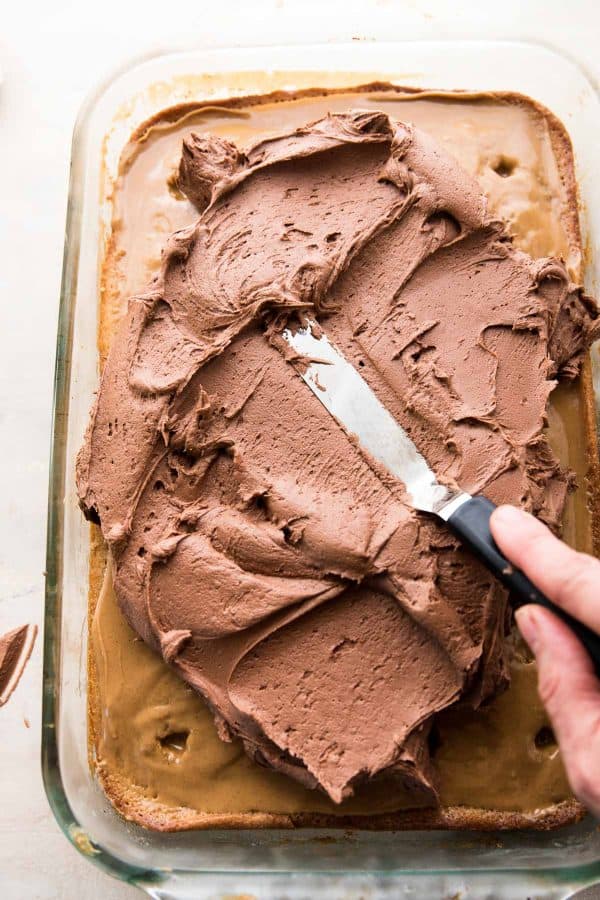 fluffy chocolate buttercream spreading over peanut butter cake