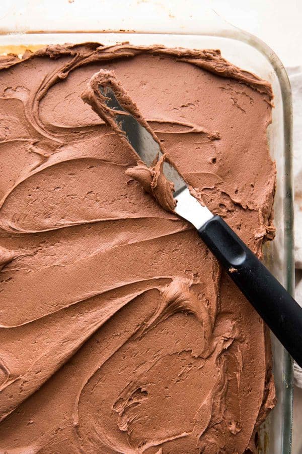 fluffy chocolate frosting spread onto sheet cake