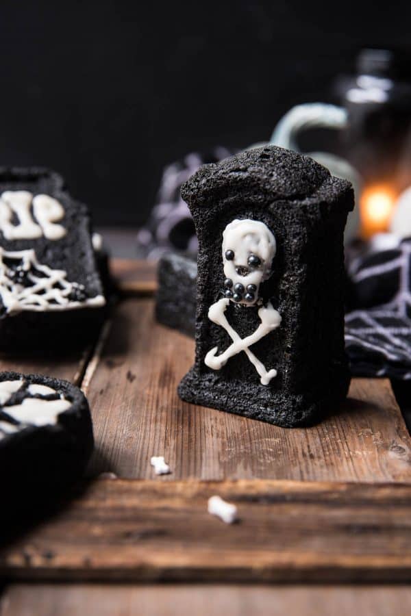 skull and crossbone tombstone cake on wooden surface