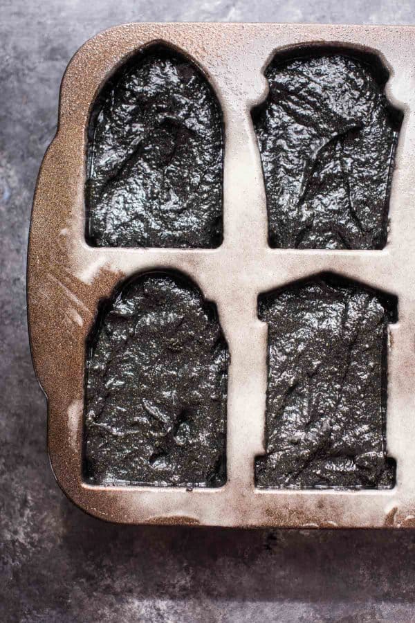 overhead view of black pumpkin cake batter in cakelet pan